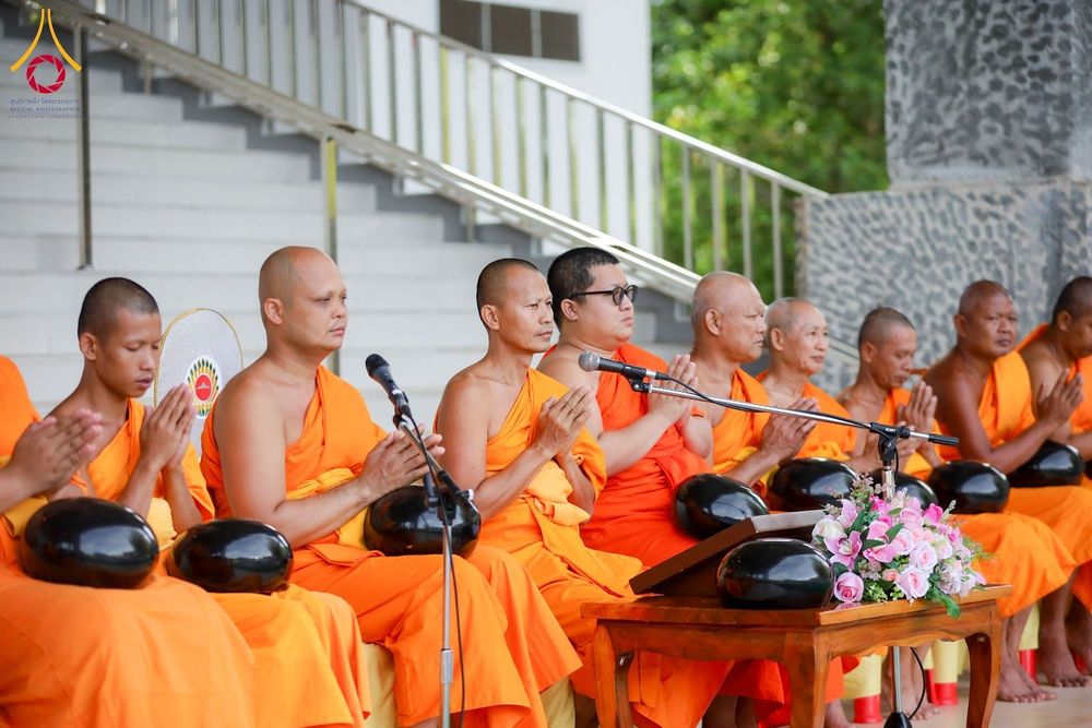 พระภิกษุสงฆ์หลายรูปนั่งพนมมือประกอบพิธีทางศาสนาในบรรยากาศสงบ