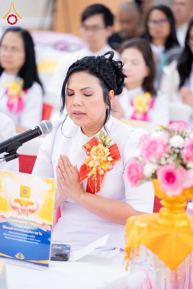 หญิงสวมชุดขาวพนมมืออธิษฐานจิตในพิธีทอดผ้าป่า