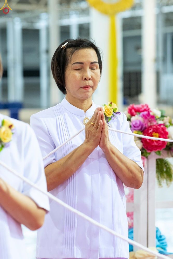 หญิงไทยสวมชุดขาวพนมมือทำสมาธิในพิธีกรรมทางศาสนา