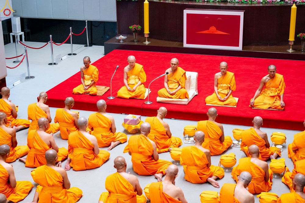 พระภิกษุและนาคนั่งเรียงแถวประกอบพิธีบรรพชาอุปสมบทภายในโบสถ์