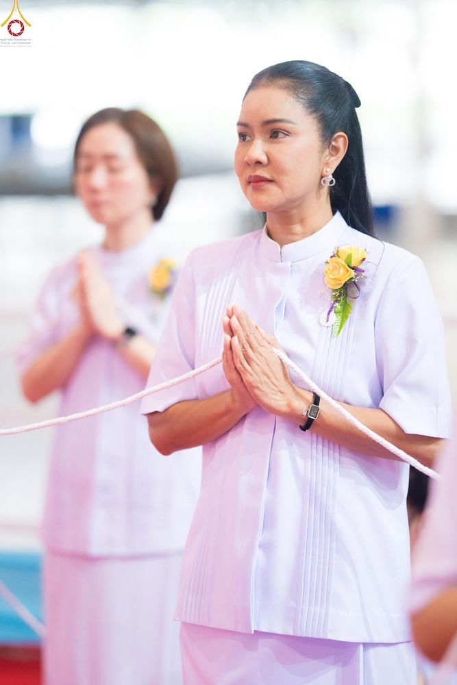 หญิงไทยสวมชุดสีขาวพนมมือด้วยความสงบในพิธีทางศาสนา