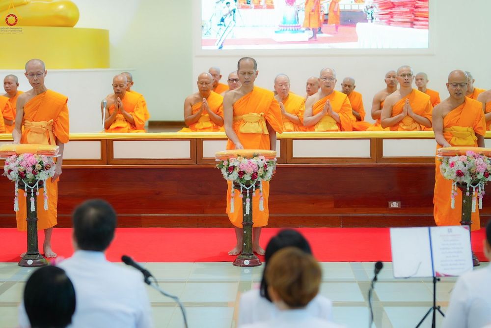 พระภิกษุสงฆ์ในจีวรสีส้มกำลังประกอบพิธีกรรมทางศาสนาภายในอาคาร