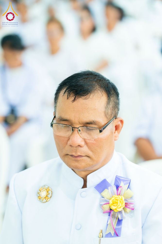 ชายสวมชุดขาวกำลังหลับตาทำสมาธิในพิธีทางศาสนา