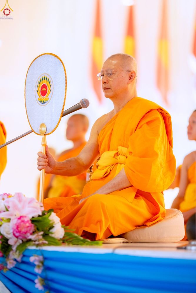 พระภิกษุสงฆ์ครองจีวรสีเหลืองทองถือตาลปัตรขณะประกอบพิธีทางศาสนา