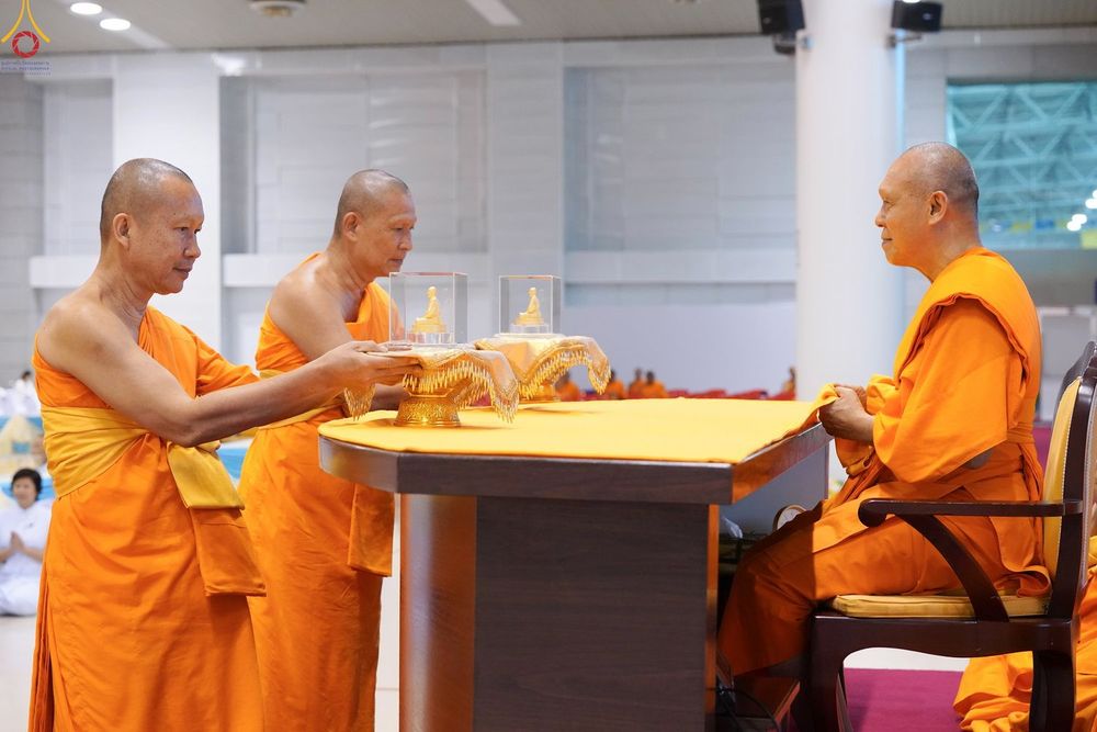 พระภิกษุสงฆ์กำลังประกอบพิธีมอบพระของขวัญภายในอาคาร