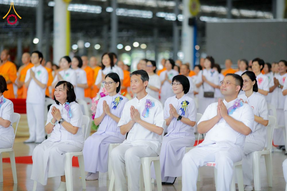 กลุ่มสาธุชนสวมชุดสีขาวนั่งพนมมือร่วมพิธีในอาคารสภาธรรมกายสากล