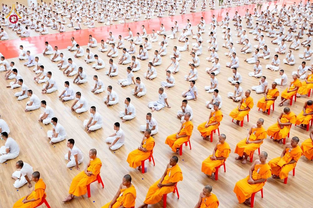 นักเรียนนายสิบตำรวจและพระสงฆ์นั่งเรียงแถวในพิธีปิดโครงการบรรพชา