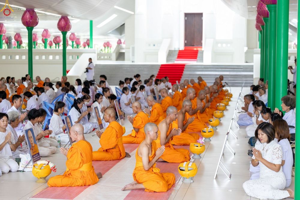 กลุ่มนาคและพุทธศาสนิกชนนั่งพนมมือประกอบพิธีบรรพชาอุปสมบทภายในอุโบสถ