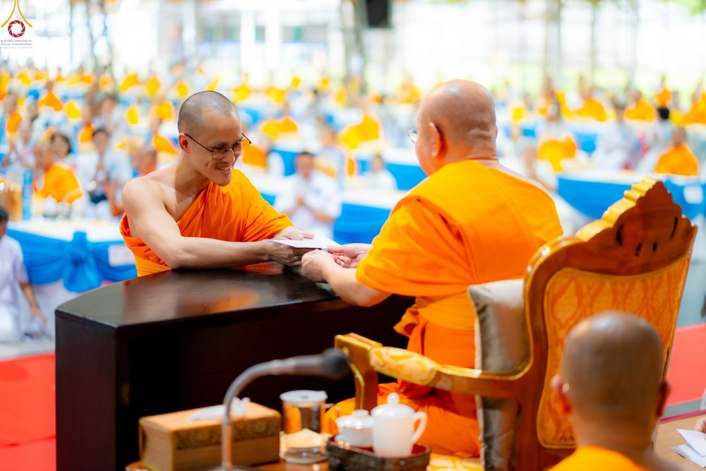 พระภิกษุสงฆ์กำลังถวายเอกสารแด่พระเถระผู้ใหญ่ในงานพิธีทางศาสนา
