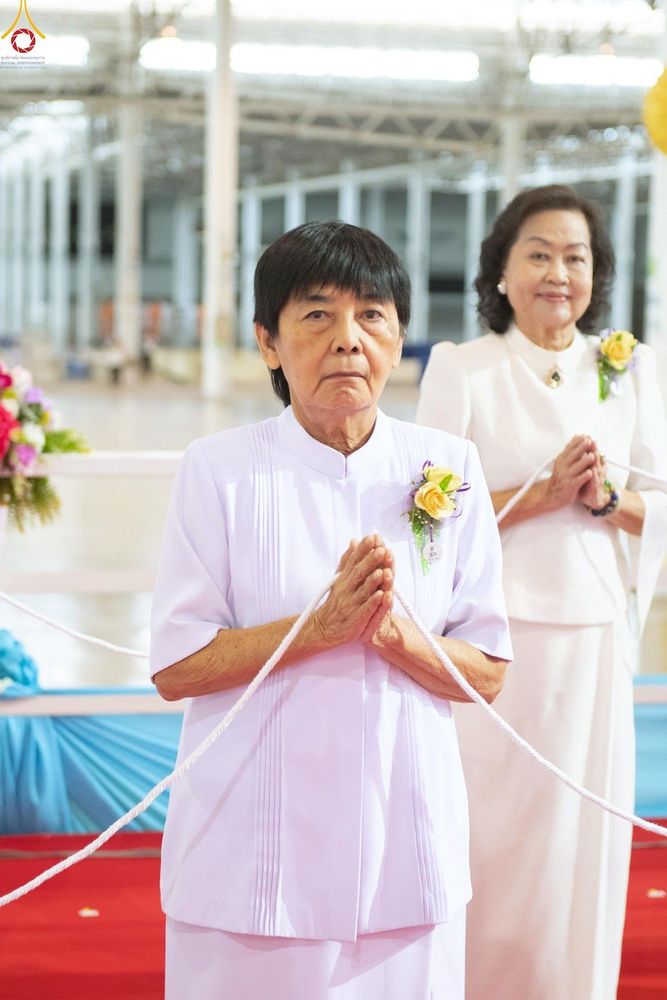 หญิงสองท่านสวมชุดสีขาวพนมมือในพิธีทางศาสนา