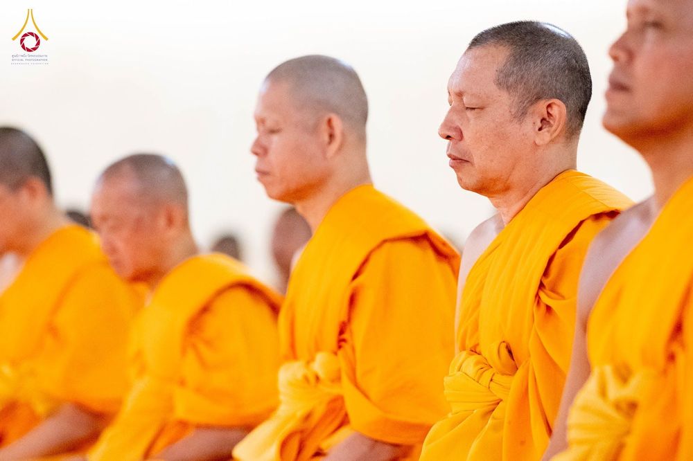 พระภิกษุสงฆ์หลายรูปกำลังนั่งสมาธิโดยหลับตาและสวมจีวรสีเหลือง