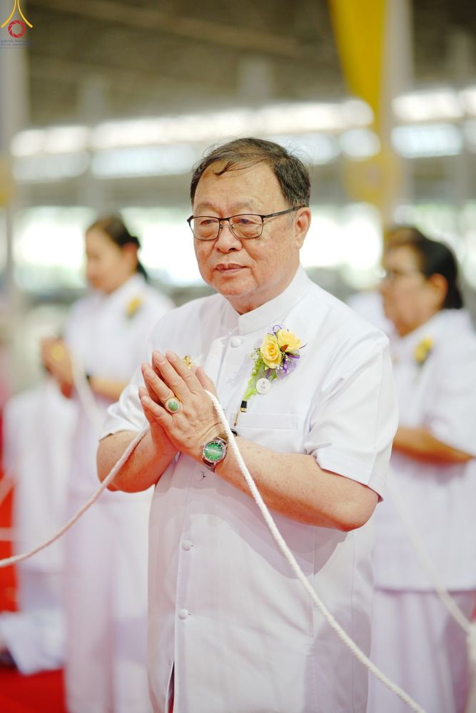 ชายสูงวัยสวมชุดขาวพนมมือด้วยความสงบในพิธีทางศาสนา