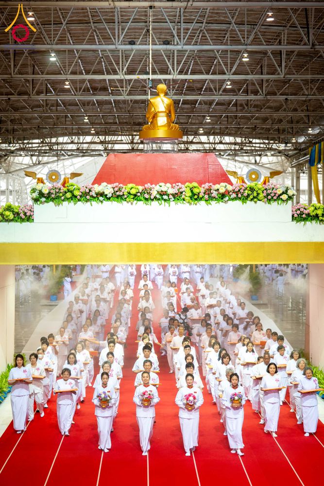 พุทธศาสนิกชนชุดขาวเดินแถวร่วมพิธีทอดผ้าป่าสมทบกฐินภายในอาคารสภาธรรมกายสากล