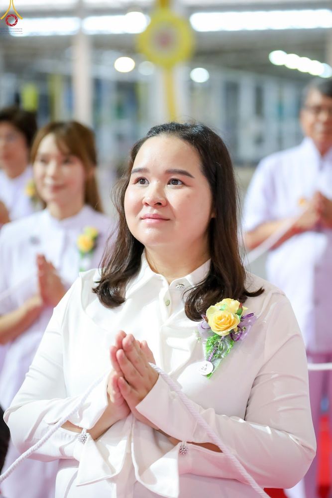 หญิงสาวสวมชุดสีขาวพนมมือด้วยความตั้งใจในพิธีทางศาสนา