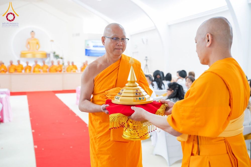 พระภิกษุสงฆ์สองรูปกำลังถือพานทองที่บรรจุพระบรมสารีริกธาตุในพิธีทางศาสนา