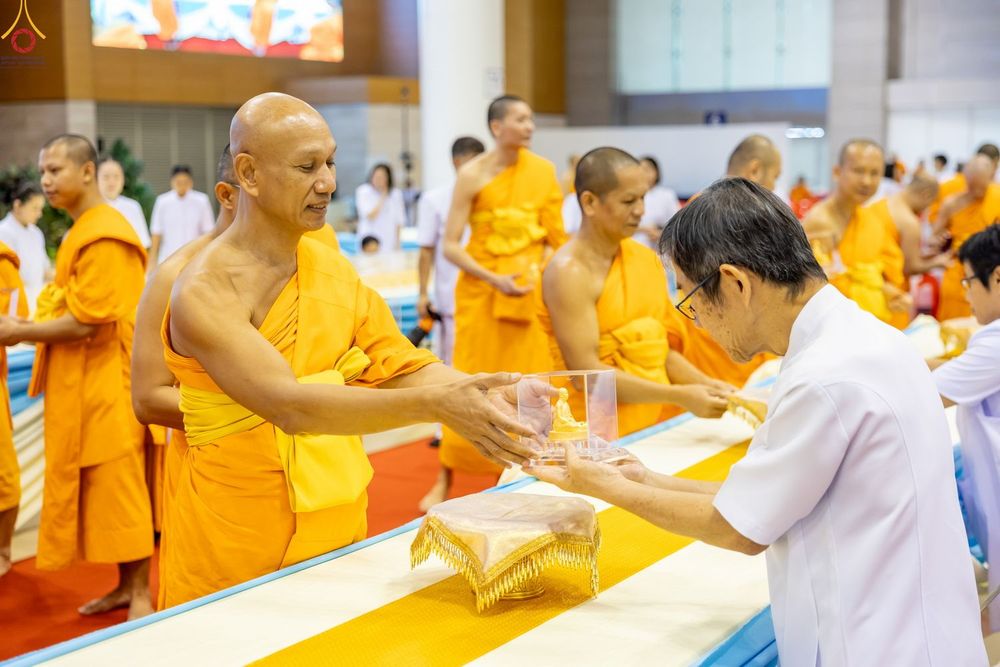 พระภิกษุส่งมอบพระของขวัญให้แก่พุทธศาสนิกชนในพิธีทางศาสนา