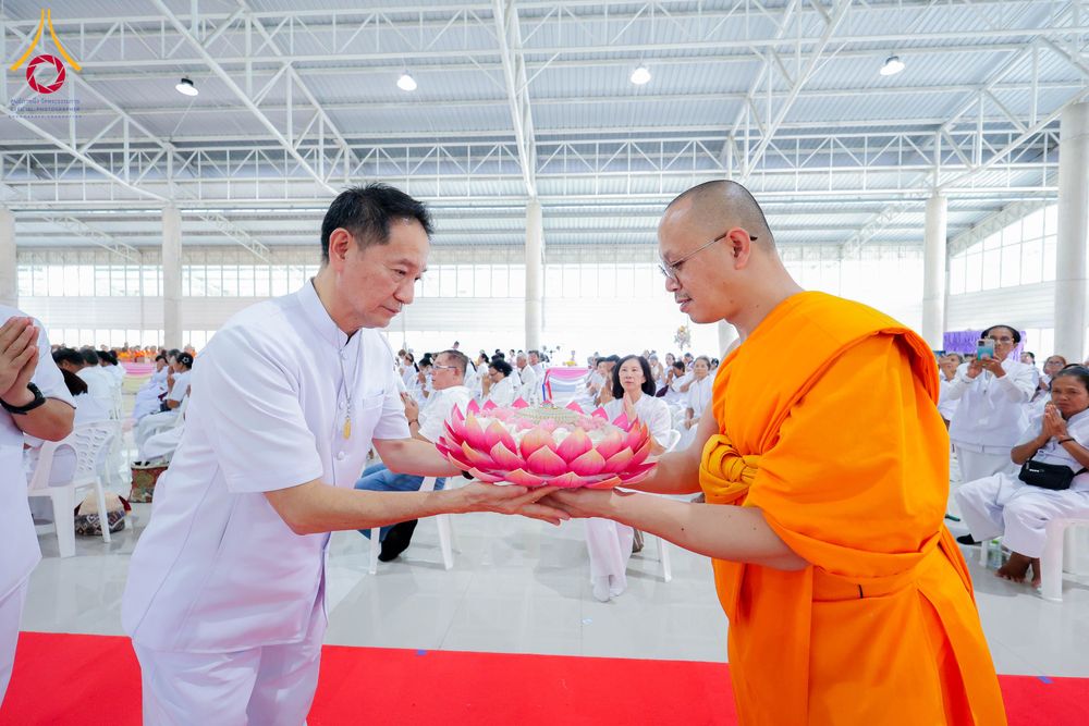 ชายชุดขาวถวายพานดอกบัวแด่พระภิกษุสงฆ์ในพิธีทางศาสนา