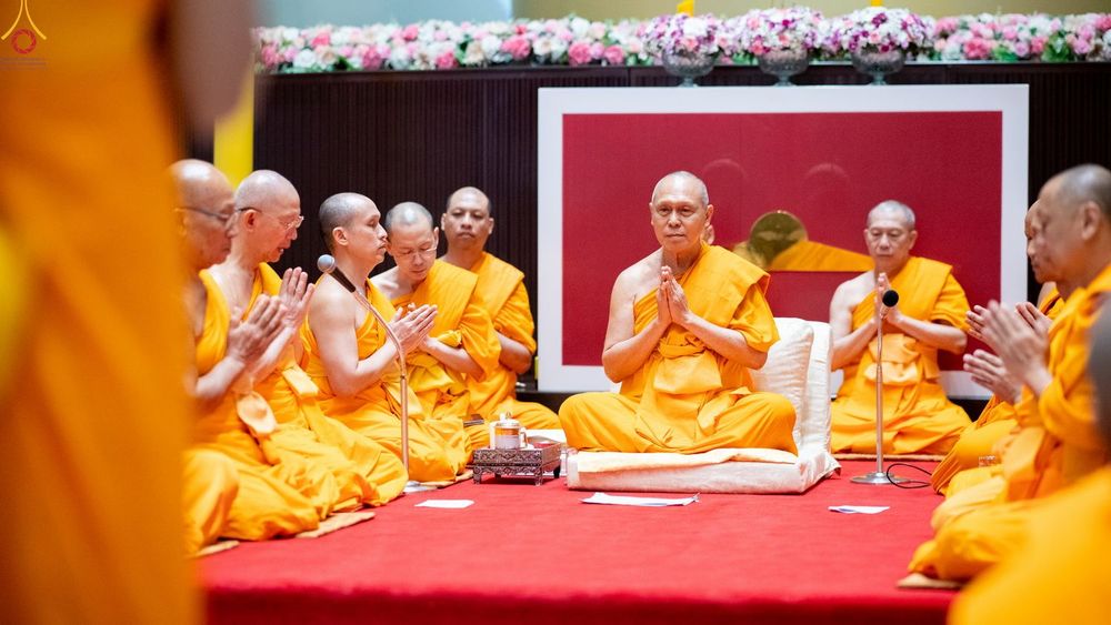 พระภิกษุสงฆ์นั่งพนมมือประกอบพิธีบรรพชาอุปสมบทภายในโบสถ์