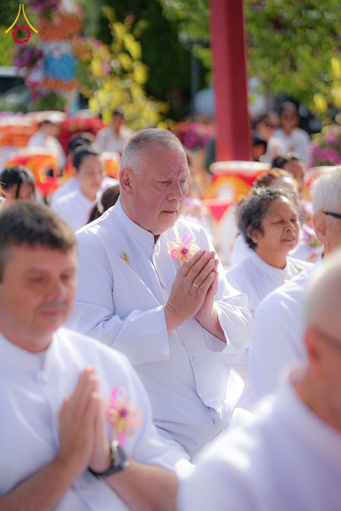 กลุ่มคนสวมชุดขาวพนมมือในพิธีทางศาสนาพุทธ