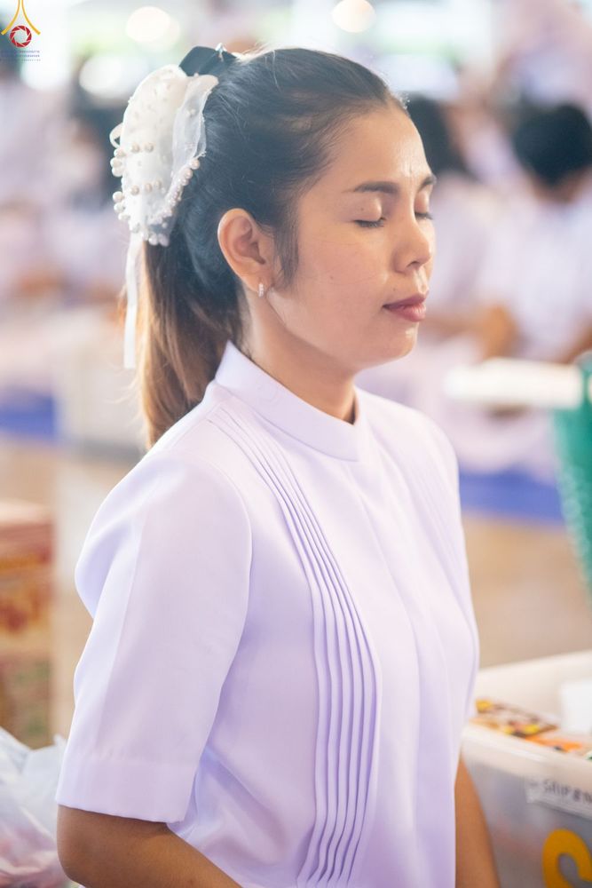 หญิงสาวสวมชุดสีขาวกำลังหลับตาทำสมาธิอย่างสงบ