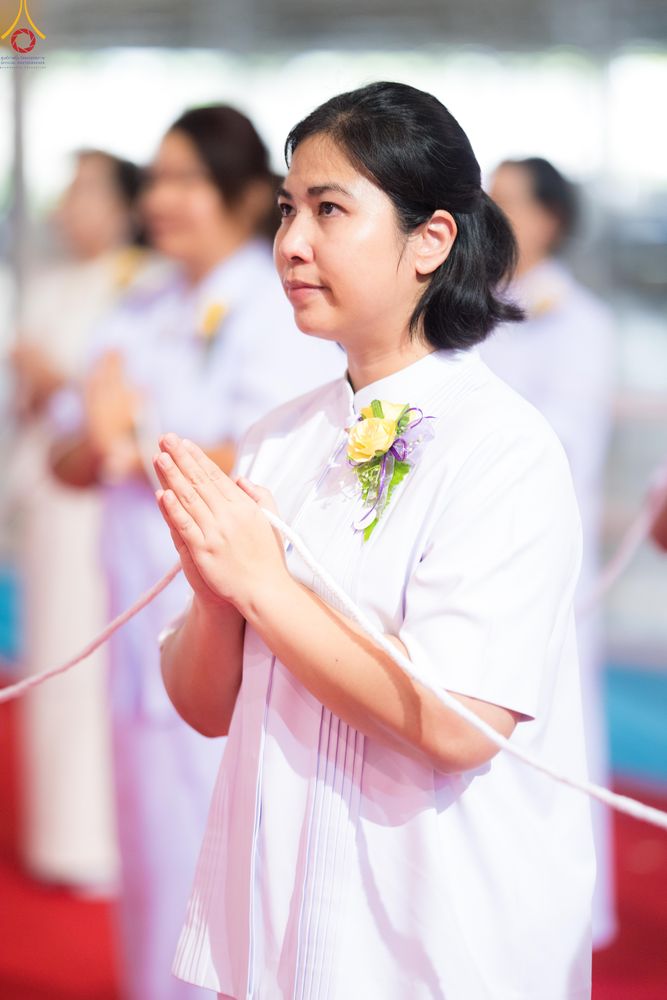 หญิงสาวสวมชุดขาวพนมมือด้วยความสงบในพิธีทางศาสนา