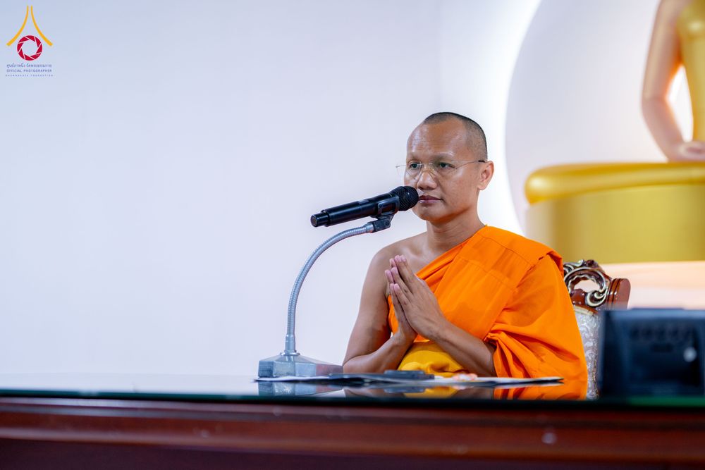 พระภิกษุสงฆ์นั่งประนมมือหน้าไมโครโฟนเพื่อแสดงธรรม