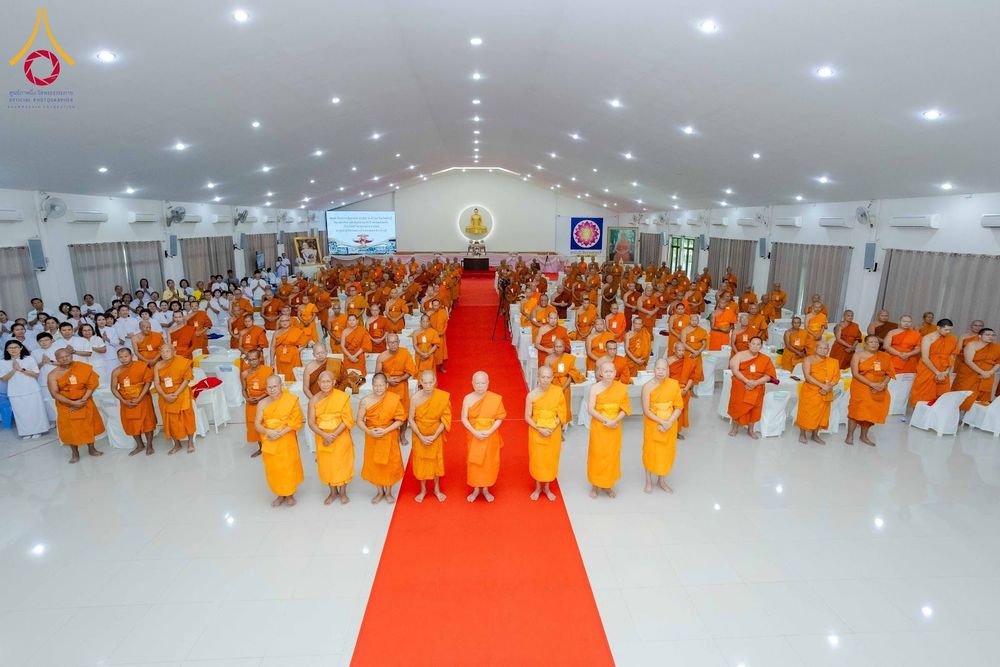 คณะสงฆ์และพุทธศาสนิกชนจำนวนมากร่วมงานสัมมนาในหอประชุมขนาดใหญ่ที่มีพรมแดงทอดยาวไปสู่ด้านหน้า