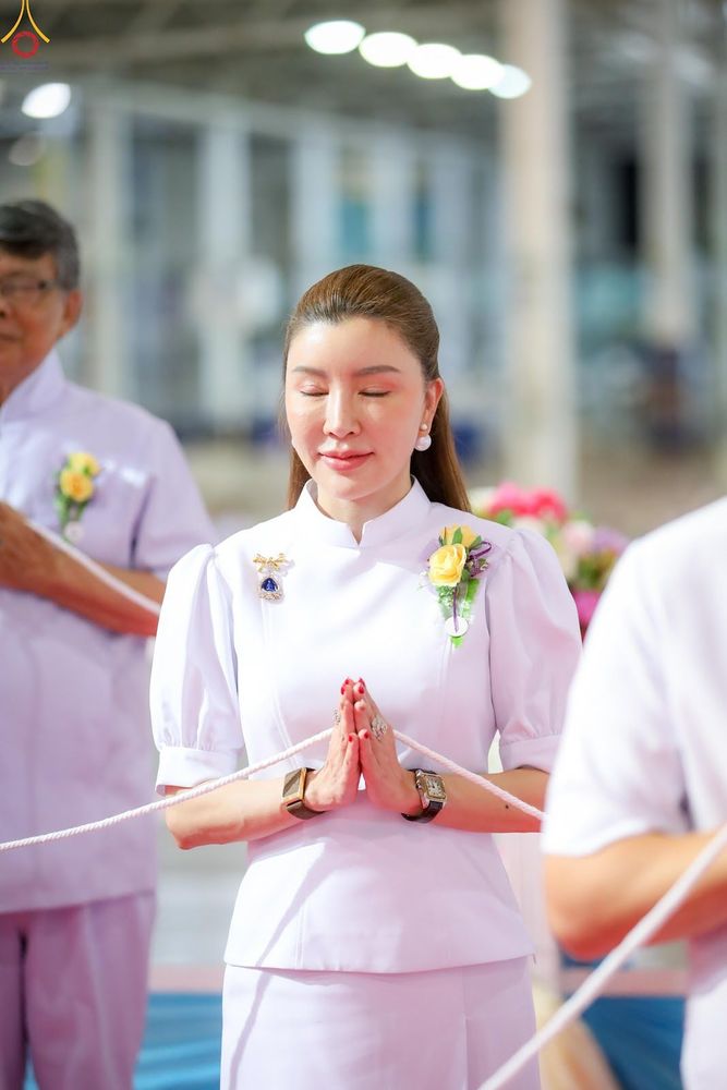 หญิงสาวสวมชุดสีขาวพนมมือด้วยความสงบในพิธีทางศาสนา ณ วัดพระธรรมกาย
