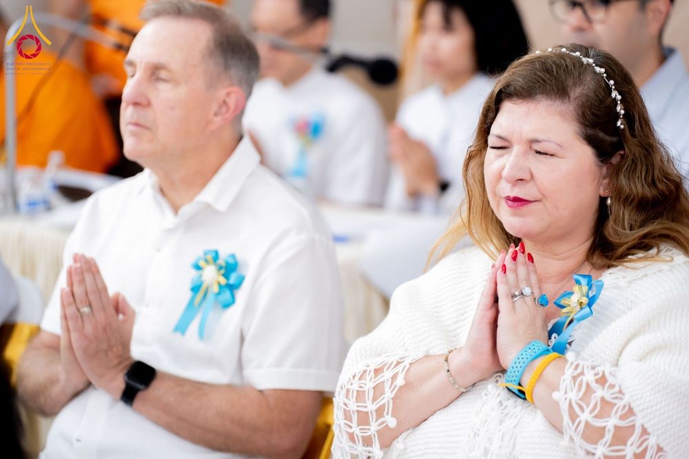 ชายและหญิงชาวต่างชาติกำลังพนมมืออธิษฐานด้วยความสงบในพิธีทางศาสนา