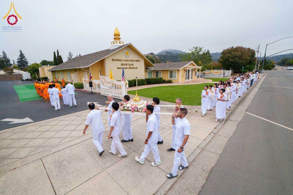 กลุ่มคนชุดขาวกำลังช่วยกันหามพานพระบรมสารีริกธาตุเดินเข้าสู่อาคารวัดพระธรรมกายซิลิคอนวัลเลย์