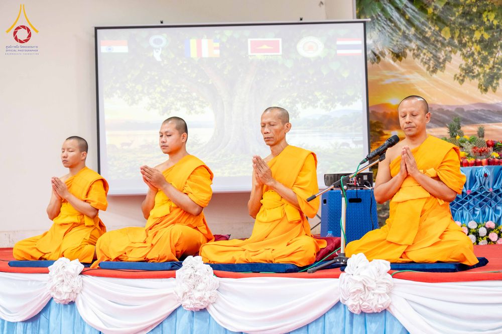 พระภิกษุสงฆ์ 4 รูปนั่งพนมมือบนเวทีเพื่อประกอบพิธีกรรมทางศาสนา