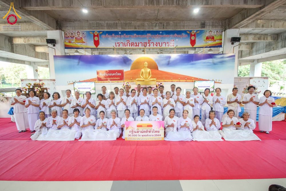 กลุ่มผู้เข้าร่วมโครงการอบรมสวมชุดสีขาวถ่ายภาพหมู่ร่วมกันในอาคาร
