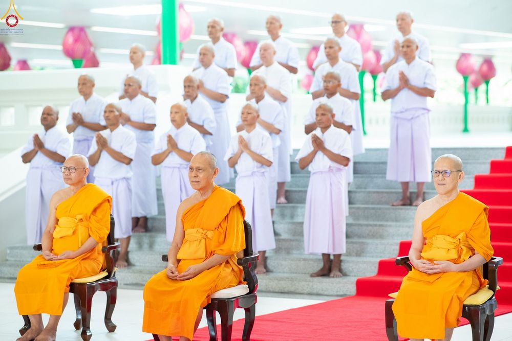 พระภิกษุสงฆ์และนาคในชุดขาวร่วมพิธีบรรพชาอุปสมบทภายในโบสถ์