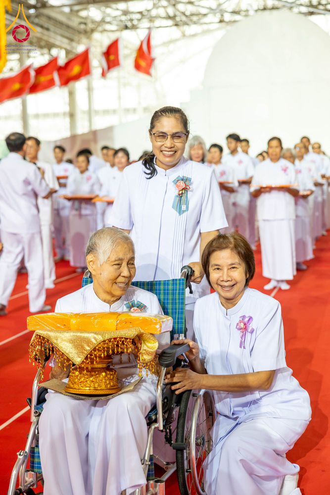 กลุ่มพุทธศาสนิกชนสวมชุดขาวร่วมพิธีทอดผ้าป่าภายในอาคารสภาธรรมกายสากล