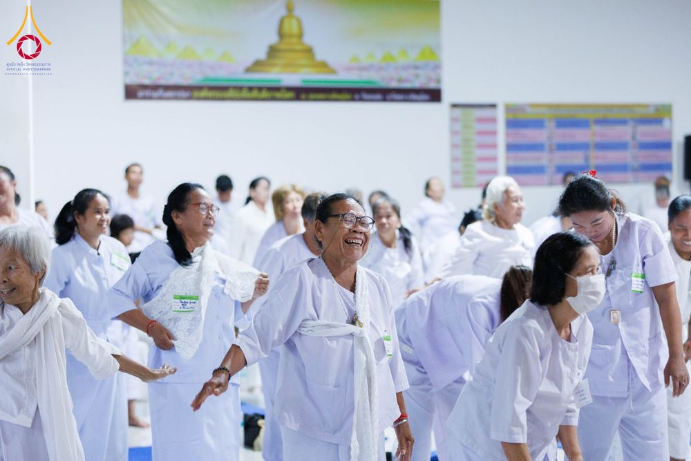 กลุ่มผู้เข้าร่วมโครงการอบรมสวมชุดสีขาวกำลังทำกิจกรรมร่วมกันด้วยความยิ้มแย้ม