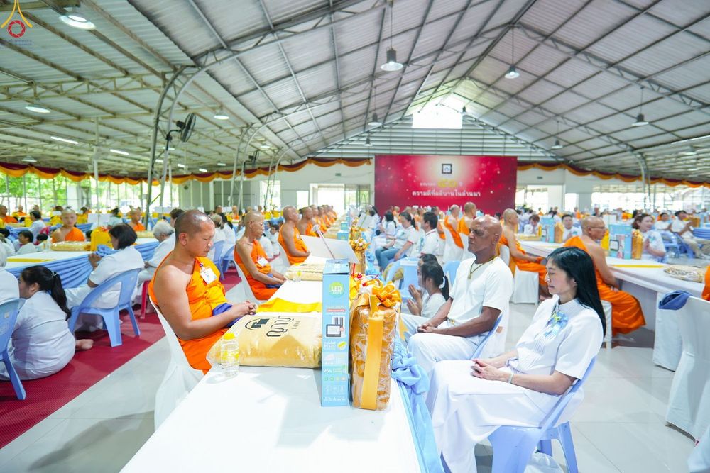 คณะสงฆ์และพุทธศาสนิกชนนั่งร่วมพิธีทำบุญภายในอาคารขนาดใหญ่
