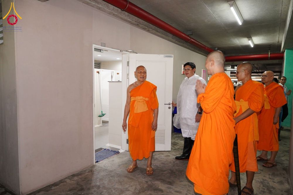 พระภิกษุสงฆ์และเจ้าหน้าที่กำลังเดินสำรวจพื้นที่ภายในอาคารจอดรถ