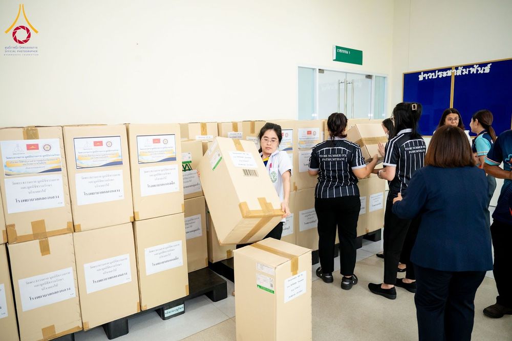 เจ้าหน้าที่กำลังช่วยกันจัดเรียงกล่องกระดาษบรรจุยาและเวชภัณฑ์จำนวนมากภายในอาคาร