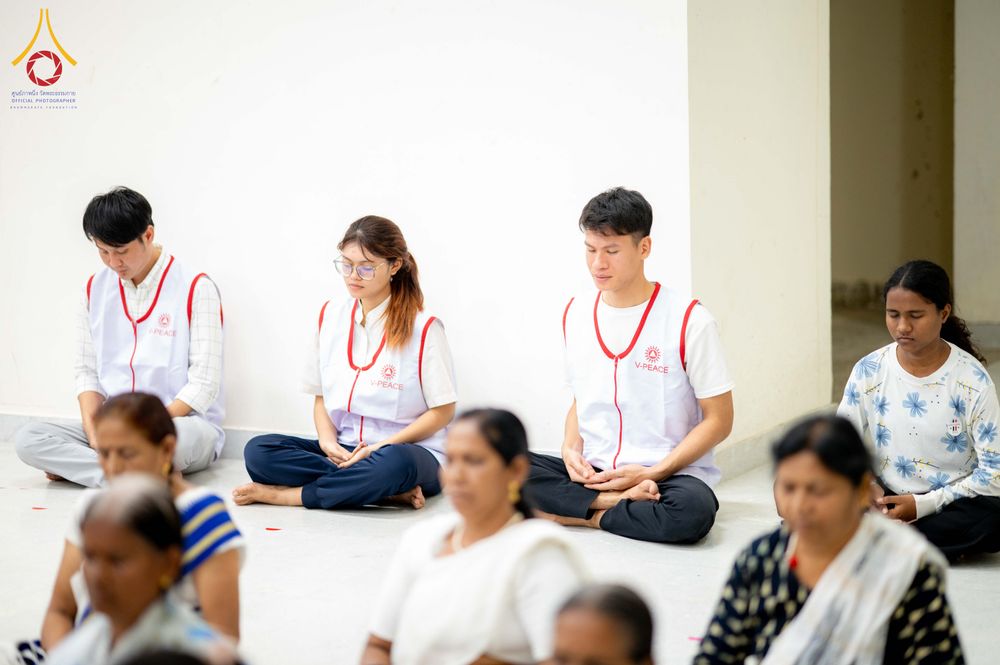 กลุ่มคนนั่งสมาธิหลับตาอย่างสงบภายในอาคาร
