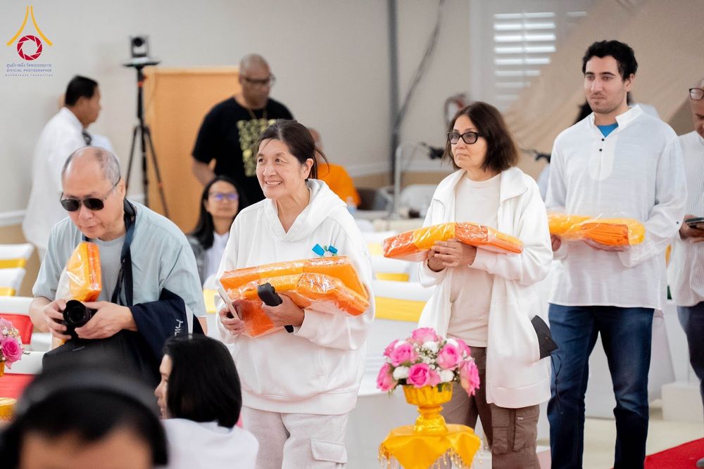 กลุ่มคนถือผ้าไตรจีวรสีเหลืองทองเตรียมร่วมพิธีทางศาสนา