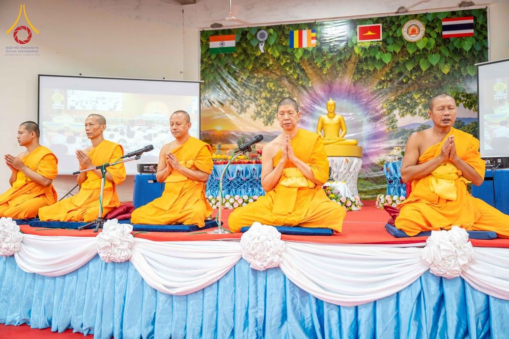 พระสงฆ์ 5 รูปนั่งพนมมือปฏิบัติธรรมบนเวทีในพิธีทางศาสนา