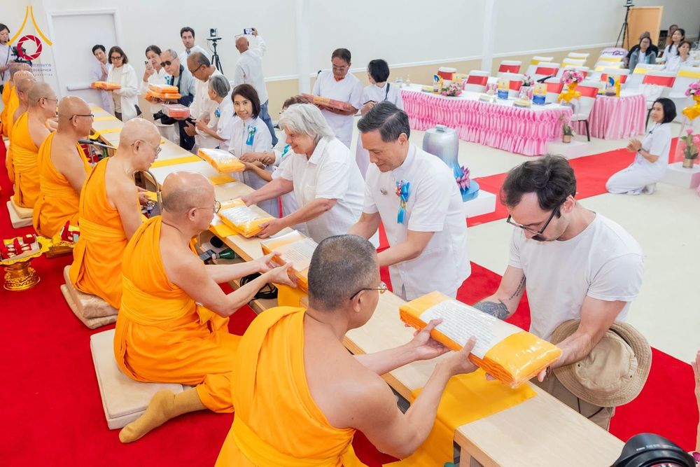 พระภิกษุสงฆ์และพุทธศาสนิกชนกำลังประกอบพิธีถวายผ้าป่าภายในอาคาร