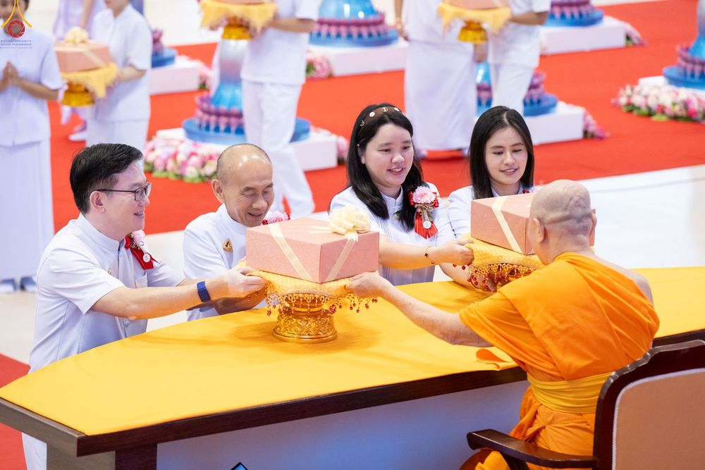 พุทธศาสนิกชนกำลังประเคนพานพุ่มผ้าป่าแด่พระภิกษุสงฆ์ในพิธีทางศาสนา