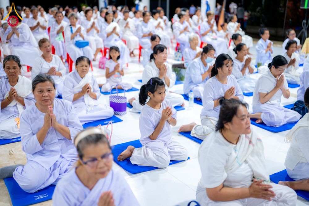 กลุ่มคนสวมชุดสีขาวนั่งพนมมือปฏิบัติธรรมในโครงการอบรมอุบาสิกาแก้ว