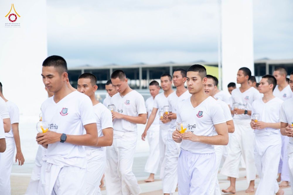 กลุ่มนักเรียนนายสิบตำรวจสวมชุดขาวถือเทียนเดินแถวประกอบกิจกรรมทางศาสนา