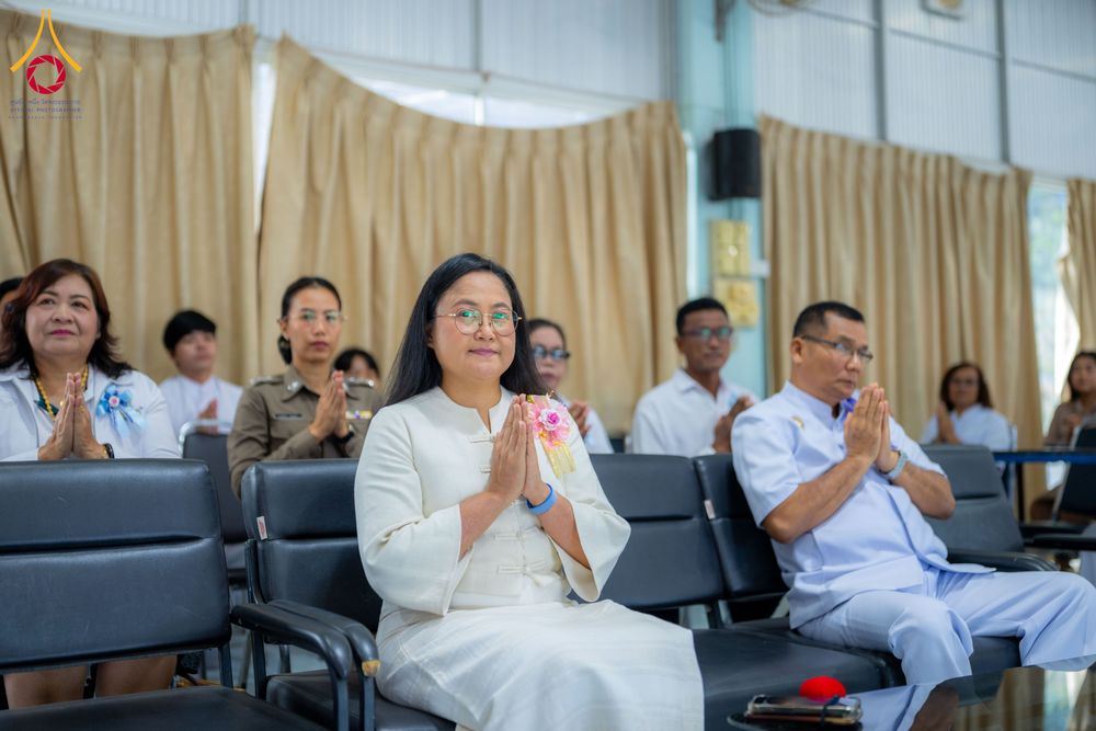 กลุ่มคนนั่งพนมมือในพิธีทางศาสนาภายในอาคาร