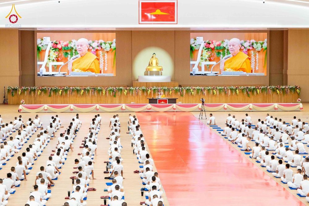 นักเรียนนายสิบตำรวจนั่งสมาธิในห้องประชุมใหญ่ โดยมีจอภาพแสดงพระภิกษุสงฆ์อยู่ด้านหน้า