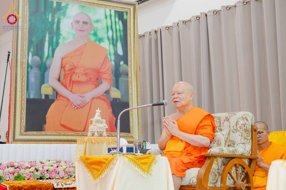 พระภิกษุสงฆ์กำลังประนมมือประกอบพิธีหน้าภาพถ่ายพระภิกษุขนาดใหญ่