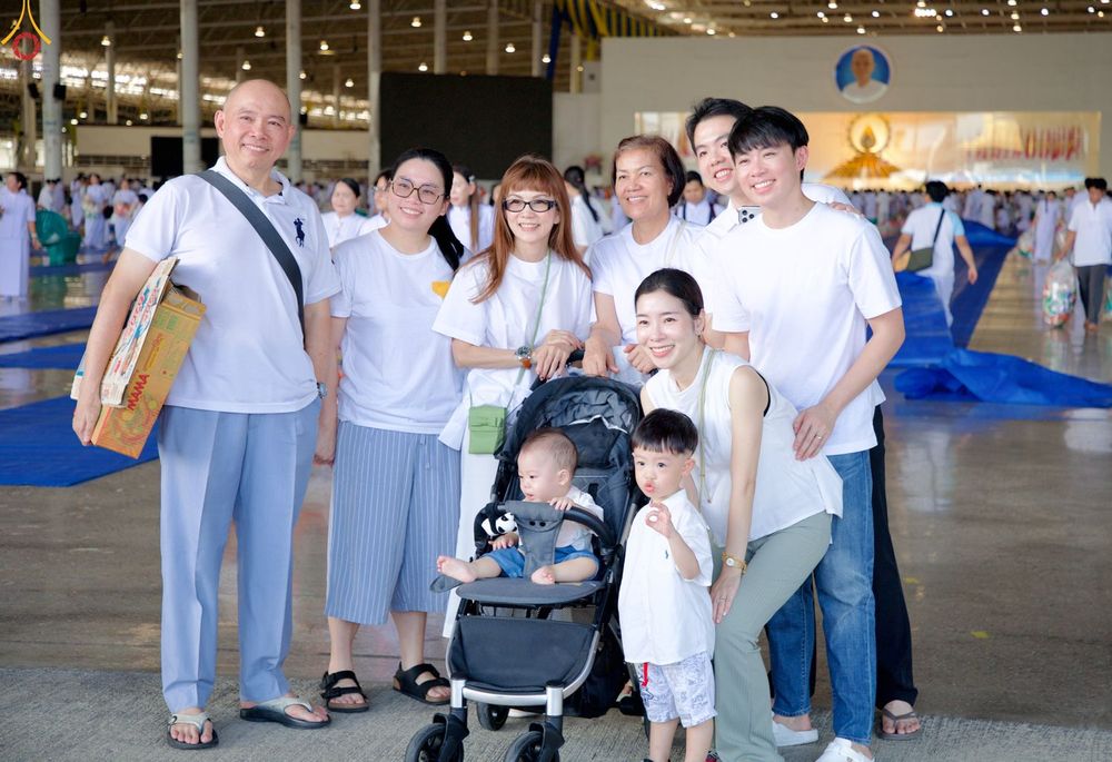 กลุ่มครอบครัวสวมเสื้อสีขาวถ่ายภาพร่วมกันในอาคารสภาธรรมกายสากล