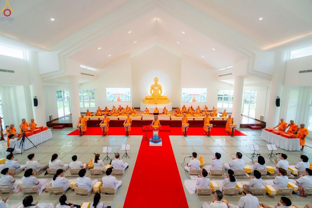 พระภิกษุสงฆ์และพุทธศาสนิกชนร่วมพิธีทางศาสนาภายในอาคารปฏิบัติธรรมที่มีพระพุทธรูปเป็นประธาน